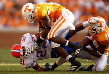 KNOXVILLE, TN - SEPTEMBER 20:  Emmanuel Moody #21 of the Florida Gators is tackled by teammates DeAngelo Willingham #24 and Eric Berry #14 of the Tennessee Volunteers during their game at Neyland Stadium on September 20, 2008 in Knoxville, Tennessee.  (Photo by Streeter Lecka/Getty Images)