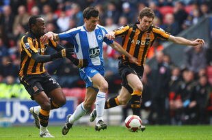 WIGAN, UNITED KINGDOM - MARCH 22:  Paul Scharner (C) of Wigan breaks past Samuel Ricketts (R) and Kamil Zayatte of Hull during the Barclays Premier League match between Wigan Athletic and Hull City at The JJB Stadium on March 22, 2009 in Wigan, England.  (Photo by Laurence Griffiths/Getty Images)