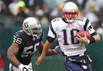 OAKLAND, CA - DECEMBER 14:  Matt Cassel #16 of the New England Patriots scrambles with the ball as Derrick Burgess #56 of the Oakland Raiders defends during an NFL game on December 14, 2008 at the Oakland-Alameda County Coliseum in Oakland, California.  (Photo by Jed Jacobsohn/Getty Images)