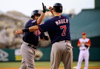 ANAHEIM, CA - JULY 23:  Jason Kubel #16 of the Minnesotta Twins is congratulated by teammate Joe Maur #7 after hitting a two-run home run off pitcher Jered Weaver #36 of the Los Angeles Angels of Anaheim during the first inning of the baseball game on July 23, 2009 in Anaheim, California.  mauer scored on the home run.  (Photo by Kevork Djansezian/Getty Images)