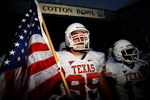 DALLAS - OCTOBER 11:   Defensive end Aaron Lewis #95 the Texas Longhorns carries a flag as he enters the field before their Red River Rivalry game against the Oklahoma Sooners at the Cotton Bowl on October 11, 2008 in Dallas, Texas.  (Photo by Ronald Martinez/Getty Images)