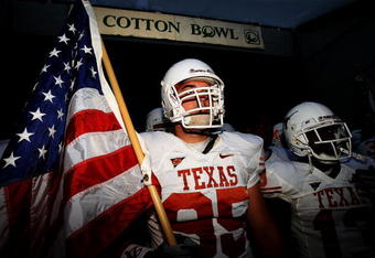 DALLAS - OCTOBER 11:   Defensive end Aaron Lewis #95 the Texas Longhorns carries a flag as he enters the field before their Red River Rivalry game against the Oklahoma Sooners at the Cotton Bowl on October 11, 2008 in Dallas, Texas.  (Photo by Ronald Martinez/Getty Images)