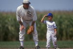 DYERSVILLE, IA - AUGUST 25: A 'ghost player' recreating the role of Chicago White Sox legend Shoeless Joe Jackson plays ball with a young tourist at the baseball field created for the motion picture 'Field of Dreams' on August 25, 1991 in Dyersville, Iowa. Rita and Al Ameskamp who, with Don and Becky Lansing, co-own the site have turned the cornfields and baseball diamond into a summertime tourist attraction, including 'ghost player' reenactments. (Photo by Jonathan Daniel/Getty Images)