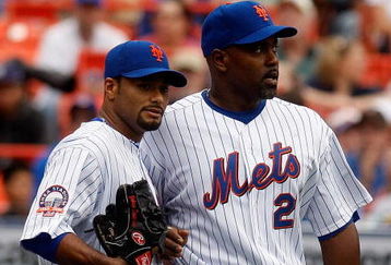 NEW YORK - APRIL 12:  Johan Santana #57 of the New York Mets talks with teammate Carlos Delgado #21 against the Milwaukee Brewers on April 12, 2008 at Shea Stadium in the Flushing neighborhood of the Queens borough of New York City.  (Photo by Nick Laham/Getty Images)