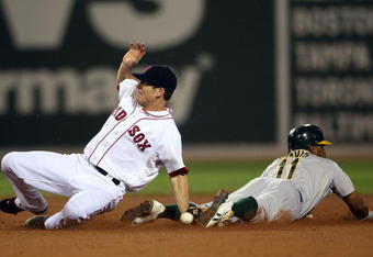 BOSTON - JULY 28:  Rajai Davis #11 of the Oakland Athletics steals second base in the 11th inning as Nick Green #22 of the Boston Red Sox fails to make the tag at Fenway Park July 28, 2009 in Boston, Massachusetts. The A's defeated the Boston Red Sox 9-8 in 11 innings. (Photo by Elsa/Getty Images)
