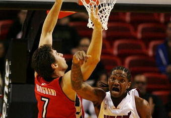 MIAMI - NOVEMBER 19:  Udonis Haslem #40 of the Miami Heat tips out an offensive rebound over Andrea Bargnani #7 of the Toronto Raptors at American Airlines Arena on November 19, 2008 in Miami, Florida. The Raptors defeated the Heat 101-95. NOTE TO USER: User expressly acknowledges and agrees that, by downloading and/or using this Photograph, user is consenting to the terms and conditions of the Getty Images License Agreement.  (Photo by Doug Benc/Getty Images)