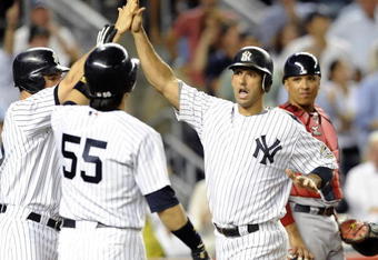 NEW YORK - AUGUST 6:  Jorge Posada #20 of the New York Yankees high fives his teammates at home plate after hitting a three run home run in the fourth inning as catcher Victor Martinez # 41 of the Boston Red Sox watches on August 6, 2009 at Yankee Stadium in the Bronx borough of New York City.  (Photo by Paul Bereswill/Getty images)