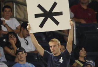 NEW YORK - AUGUST 6:  A New York Yankees fan holds up a sign with an asterisk as David Ortiz of the Boston Red Sox comes up to bat in the eighth inning against the New York Yankees August 6, 2009 in New York City.  The Yankees defeated the Red Sox 13-6.  (Photo by Paul Bereswill/Getty images)