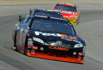 LONG POND, PA - AUGUST 03:  Denny Hamlin, driver of the #11 FedEx Express Toyota, leads Jimmie Johnson, driver of the #48 Lowe's Chevrolet, and Jeff Gordon, driver of the #24 DuPont Chevrolet, during the NASCAR Sprint Cup Series Sunoco Red Cross Pennsylvania 500 at the Pocono Raceway on August 3, 2009 in Long Pond, Pennsylvania.  (Photo by Doug Pensinger/Getty Images)