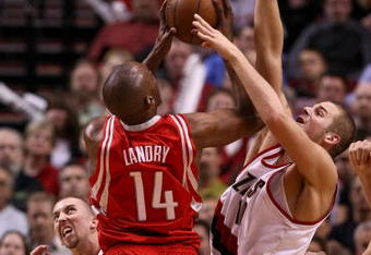 PORTLAND, OR - APRIL 28:  Carl Landry #14 of the Houston Rockets is guarded by Joel Przybilla #10 and Steve Blake #2 of the Portland Trail Blazers during Game 5 of the Western Conference Quarterfinals of the NBA Playoffs on April 28, 2009 at the Rose Garden in Portland, Oregon. NOTE TO USER: User expressly acknowledges and agrees that, by downloading and or using this Photograph, user is consenting to the terms and conditions of the Getty Images License Agreement.  (Photo by Jonathan Ferrey/Getty Images)