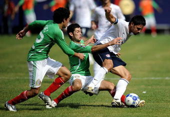 EAST RUTHERFORD, NJ - JULY 26:  Efrain Juarez #22 and Israel Castro #8 of Mexico fight for the ball with Brian Ching #11 of the United States in the CONCACAF Gold Cup Championship match at Giants Stadium on July 26, 2009 in East Rutherford, New Jersey.  (Photo by Jeff Zelevansky/Getty Images)