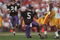 1 Jan 1996:  Running back D'Wayne Bates #5 of the Northwestern Wildcats reaches for his helmet as he attempts to remove a clump of grass from his face mask following a carry in the Wildcats 41-32 loss to the USC Trojans in the 1996 Rose Bowl game held at