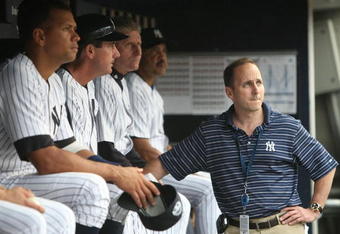 NEW YORK - JULY 2: Alex Rodriguez #2 (L) of the New York Yankees sits on the bench, joined by Yankees General Manager Brian Cashman (R) before a game against the Seattle Mariners at Yankee Stadium on July 2, 2009 in the Bronx borough of New York City.  (Photo by Nick Laham/Getty Images)
