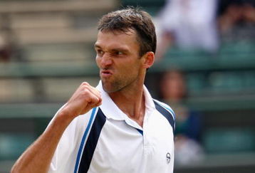 WIMBLEDON, ENGLAND - JUNE 26:  Ivo Karlovic of Croatia plays a backhand during the men's singles third round match against Jo-Wilfried Tsonga of France  on Day Five of the Wimbledon Lawn Tennis Championships at the All England Lawn Tennis and Croquet Club on June 26, 2009 in London, England.  (Photo by Clive Brunskill/Getty Images)