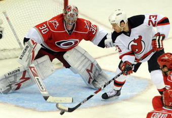 RALEIGH, NC - APRIL 26: Goalie Cam Ward #30 of the Carolina Hurricanes keeps a close eye on the puck as David Clarkson #23 of the New Jersey Devils tries to get it past him in the third period of Game Six of the Eastern Conference Quarterfinals of the 2009 Stanley Cup Playoffs on April 26, 2009 at the RBC Center in Raleigh, North Carolina. (Photo by Steve Dykes/Getty Images)