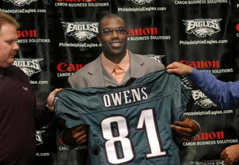PHILADELPHIA - MARCH 16:  (L-R) Philadelphia Eagles head coach Andy Reid, newly acquired Philadelphia Eagles wide receiver Terrell Owens and Philadelphia Eagles owner Jeffrey Lurie hold Owens' #81 Philadelphia Eagles jersey during a news conference March 16, 2004 in Philadelphia, Pennsylvania. Terrell Owens signed a $42 million dollar deal with the Philadelphia Eagles after he was acquired in a three way trade with the San Francisco 49ers and the Baltimore Ravens. (Photo by William Thomas Cain/Getty Images)