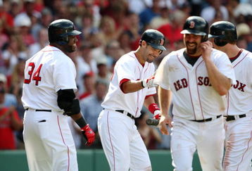 BOSTON - JULY 30:  Designated hitter David Ortiz #34 of the Boston Red Sox smiles with teammates Mike Lowell #25 Jason Bay #44 and Kevin Youkilis #20 after hitting a three-run home run against the Oakland A's in the seventh inning to give the Red Sox a 6-5 lead on July 30, 2009 at Fenway Park in Boston, Massachusetts.  (Photo by Elsa/Getty Images)