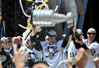 PITTSBURGH - JUNE 15:  Sidney Crosby #87 of the Pittsburgh Penguins holds the Stanley Cup as Maxime Talbot #25 of the Penguins sprays the crowd during Stanley Cup Champion Victory Parade on June 15, 2009 in Pittsburgh, Pennsylvania.  (Photo by Jamie Sabau/Getty Images)