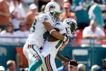 MIAMI - NOVEMBER 23:  Wide receiver Greg Camarillo #83 of the Miami Dolphins celebrates with Ted Ginn Jr. #19 after his touchdown catch in the first quarter against the New England Patriots at Dolphin Stadium on November 23, 2008 in Miami, Florida.  (Photo by Doug Benc/Getty Images)