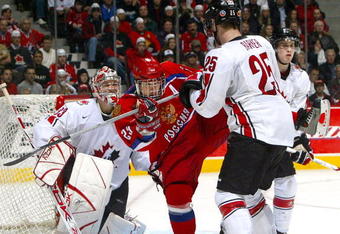 VANCOUVER - JANUARY 5: Cam Barker #25 of Team Canada checks Sergei Shirokov #29 of Team Russia as goaltender Justin Pogge #33 gets into position during their gold medal game at the World Junior Hockey Championships at General Motors Place in Vancouver, Canada.  Team Canada beat Team Russia 5-0 to win the gold medal.   (Photo by Dave Sandford/Getty Images)