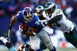 EAST RUTHERFORD, NJ - JANUARY 11: Derrick Ward #34 of the New York Giants runs against Darren Howard #90 of the Philadelphia Eagles during the NFC Divisional Playoff Game on January 11, 2009 at Giants Stadium in East Rutherford, New Jersey.  (Photo by Chris McGrath/Getty Images)