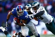 EAST RUTHERFORD, NJ - JANUARY 11: Derrick Ward #34 of the New York Giants runs against Darren Howard #90 of the Philadelphia Eagles during the NFC Divisional Playoff Game on January 11, 2009 at Giants Stadium in East Rutherford, New Jersey.  (Photo by Chris McGrath/Getty Images)