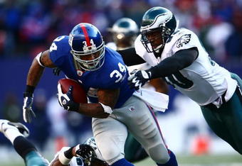 EAST RUTHERFORD, NJ - JANUARY 11: Derrick Ward #34 of the New York Giants runs against Darren Howard #90 of the Philadelphia Eagles during the NFC Divisional Playoff Game on January 11, 2009 at Giants Stadium in East Rutherford, New Jersey.  (Photo by Chris McGrath/Getty Images)