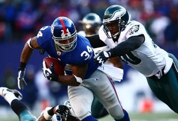 EAST RUTHERFORD, NJ - JANUARY 11: Derrick Ward #34 of the New York Giants runs against Darren Howard #90 of the Philadelphia Eagles during the NFC Divisional Playoff Game on January 11, 2009 at Giants Stadium in East Rutherford, New Jersey.  (Photo by Chris McGrath/Getty Images)