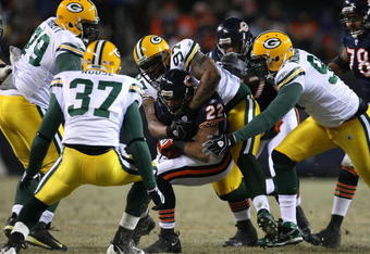 CHICAGO - DECEMBER 22: Matt Forte #22 of the Chicago Bears is gang-tackled by Johnny Jolly #97, Michael Montgomery #96, Ryan Pickett #79 and Aaron Rouse #37 of the Green Bay Packers on December 22, 2008 at Soldier Field in Chicago, Illinois. The Bears defeated the Packers 20-17 in overtime. (Photo by Jonathan Daniel/Getty Images)