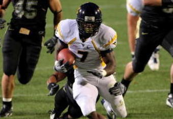 BOULDER, CO - SEPTEMBER 18:  Running back Noel Devine #7 of the West Virginia Mountaineers tries to elude the Colorado Buffaloes defense at Folsom Field September 18, 2008 in Boulder, Colorado. Colorado defeated West Virginia 17-14 in overtime.  (Photo by Doug Pensinger/Getty Images)