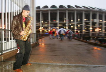 ST LOUIS - OCTOBER 26:  A saxophone player entertains fans as the enter a rainy Busch Stadium before game three of the World Series between the Boston Red Sox and the St. Louis Cardinals on October 26, 2004 at Busch Stadium in St. Louis, Missouri. (Photo by Jed Jacobsohn/Getty Images)