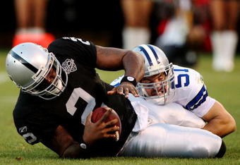 OAKLAND, CA - AUGUST 13:  Quarterback JaMarcus Russell #2 of the Oakland Raiders is sacked by Keith Brooking #51 of the Dallas Cowboys in the first quarter during the preseason game at Oakland-Alameda County Coliseum on August 13, 2009 in Oakland, California. (Photo by Jed Jacobsohn/Getty Images)