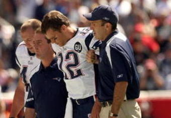 FOXBORO, MA - SEPTEMBER 7:  Quarterback Tom Brady #12 of the New England Patriots walks off the field with the aid of the Patriots staff after being injured on a play during their NFL game against the Kansas City Chiefs on September 7, 2008 at Gillette Stadium in Foxboro, Massachusetts. The Patriots defeated the Chiefs 17-10. (Photo by Elsa Garrison/Getty Images)