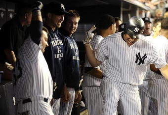 NEW YORK - AUGUST 09:  Mark Teixeira #25 of the New York Yankees is greeted by teammates after hitting a solo home run in the eighth inning against the Boston Red Sox during their game on August 9, 2009 at Yankee Stadium in the Bronx Borough of New York City.  (Photo by Jeff Zelevansky/Getty Images)