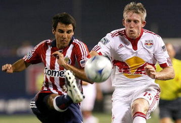 EAST RUTHERFORD, NJ - AUGUST 15: Jonathan Bornstein #13 of the Chivas USA battles for the ball against John Wolyniec #15 of the New York Red Bulls at Giants Stadium in the Meadowlands on August 15 2009 in East Rutherford, New Jersey. (Photo by Chris Trotman/Getty Images for New York Red Bull)