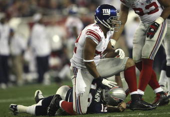 GLENDALE, AZ - FEBRUARY 03:  Defensive end Osi Umenyiora #72 of the New York Giants sits on Tom Brady #12 of the New England Patriots in the second quarter of Super Bowl XLII on February 3, 2008 at the University of Phoenix Stadium in Glendale, Arizona.  (Photo by Elsa/Getty Images)