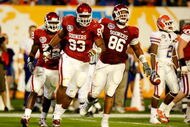 MIAMI - JANUARY 08:  (L-R) Keenan Calhoun #22, Gerald McCoy #93 and Adrian Taylor #86 of the Oklahoma Sooners celebrate a defensive stop against the Florida Gators during the FedEx BCS National Championship game at Dolphin Stadium on January 8, 2009 in Miami, Florida.  (Photo by Marc Serota/Getty Images)