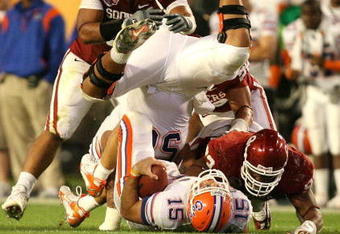 MIAMI - JANUARY 08:  Tim Tebow #15 of the Florida Gators is tackled by Gerald McCoy #93 of the Oklahoma Sooners as Maurkice Pouncey #56 of Florida flips over Tebow during the FedEx BCS National Championship game at Dolphin Stadium on January 8, 2009 in Miami, Florida.  (Photo by Doug Benc/Getty Images)