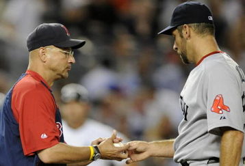 NEW YORK - AUGUST 6:  Manager Terry Francona of the Boston Red Sox takes the ball from pitcher John Smoltz #29 as he takes him out of the game in the fourth inning against the New York Yankees on August 6, 2009 at Yankee Stadium in the Bronx borough of New York City. The Yankees defeated the Red Sox 13-6.  (Photo by Paul Bereswill/Getty images)