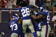 EAST RUTHERFORD, NJ - AUGUST 17: Jeremy Clark #73, DeAndre Wright #26, and Jonathan Goff #54 of the New York Giants celebrate with teammate Tommie Hill #63 after his interception, returned for a game-winning touchdown against Carolina Panthers during a preseason NFL game on August 17, 2009 at Giants Stadium in East Rutherford, New Jersey. (Photo by Jared Wickerham/Getty Images)
