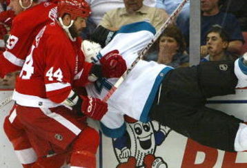 DETROIT - MAY 5:  Johan Franzen #93 and Todd Bertuzzi #44 both of the Detroit Red Wings lay a check on Kyle McLaren #4 of the San Jose Sharks during Game Five of the 2007 NHL Western Conference Semifinals on May 5, 2007 at Joe Louis Arena in Detroit, Michigan.  (Photo by Dave Sandford/Getty Images)