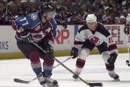 31 May 2001:  Ray Bourque #77 of the Colorado Avalanche passes the puck as John Madden #11 of the New Jersey Devils defends during game three of the NHL Stanley Cup Finals at Continental Airlines Arena in East Rutherford, New Jersey.  DIGITAL IMAGE Mandatory Credit: Elsa/ALLSPORT