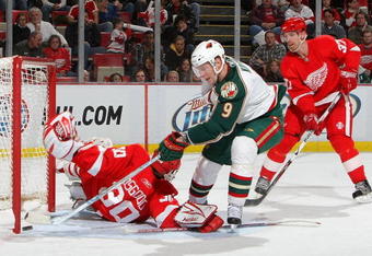 DETROIT - FEBRUARY 12:  Chris Osgood #30 of the Detroit Red Wings is beat by Mikko Koivu #9 of the Minnesota Wild as Mikael Samuelsson #37 of the Detroit Red Wings looks on during their NHL game at Joe Louis Arena February 12, 2009 in Detroit, Michigan.(Photo By Dave Sandford/Getty Images)