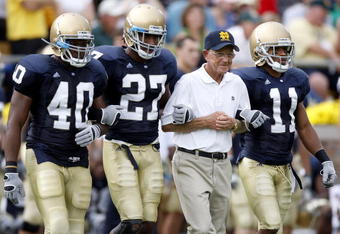 SOUTH BEND, IN - SEPTEMBER 13:  Former head coach Lou Holtz of the Notre Dame Fighting Irish walks out for the coin toss with David Grimes #11, David Bruton #27 and Maurice Crum #40 prior to playing the Michigan Wolverines on September 13, 2008 at Notre Dame Stadium in South Bend, Indiana.  (Photo by Gregory Shamus/Getty Images)
