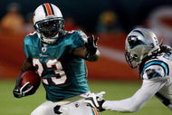 MIAMI - AUGUST 22:  Running back Ronnie Brown #23 of the Miami Dolphins tries to avoid a tackle attempt by Charles Godfrey #30 of the Carolina Panthers during a pre-season game at Land Shark Stadium on August 22, 2009 in Miami, Florida.  (Photo by Doug Benc/Getty Images)