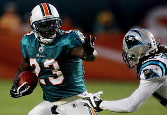 MIAMI - AUGUST 22:  Running back Ronnie Brown #23 of the Miami Dolphins tries to avoid a tackle attempt by Charles Godfrey #30 of the Carolina Panthers during a pre-season game at Land Shark Stadium on August 22, 2009 in Miami, Florida.  (Photo by Doug Benc/Getty Images)