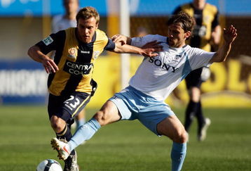 GOSFORD, AUSTRALIA - AUGUST 22:  Adam Kwasnik of the Mariners is challenged by Karol Kisel of Sydney during the round three A-League match between the Central Coast Mariners and Sydney FC at Bluetongue Stadium on August 22, 2009 in Gosford, Australia.  (Photo by Brendon Thorne/Getty Images)