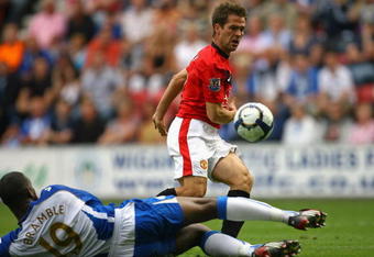 WIGAN, ENGLAND - AUGUST 22:  Michael Owen of Manchester United beats Titus Bramble of Wigan Athletic to score the 4:0 goal during the Barclays Premier League match between Wigan Athletic and Manchester United at the DW Stadium on August 22, 2009 in Wigan, England.  (Photo by Alex Livesey/Getty Images)