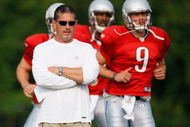 ALLEN PARK, MI - AUGUST 04: Head coach Jim Schwartz looks on while Matthew Stafford #9 and Daunte Culpepper #11 warm up during training camp at the Detroit Lions Headquarters and Training Facility on August 4, 2009 in Allen Park, Michigan. (Photo by Gregory Shamus/Getty Images)