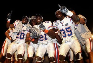 MIAMI - JANUARY 08:  Dorian Munroe #20, Major Wright #21 and Ahmad Black #35 of the Florida Gators celebrate with the trophy after defeating the Oklahoma Sooners in the FedEx BCS National Championship Game at Dolphin Stadium on January 8, 2009 in Miami, Florida. The Gators won the game by a score of 24-14.  (Photo by Donald Miralle/Getty Images)